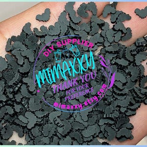 Puede incluir: Una gran cantidad de adornos de resina negros en forma de murciélago. Los adornos están esparcidos en una mano. DIY Supplier MiMaxxy Gracias por su preferencia MiMaxxy Etsy.com