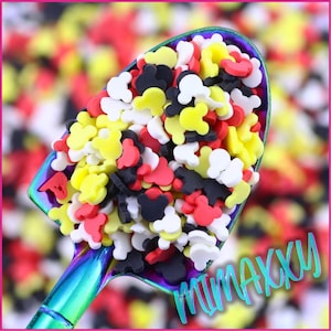 May include: A scoop filled with colorful Mickey Mouse head sprinkles. The sprinkles are red, yellow, black, and white.