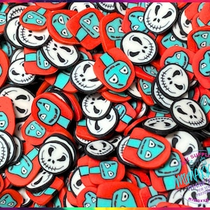 May include: A close-up shot of a pile of colorful polymer clay pieces. The pieces feature a Jack Skellington design with a white face, black details, and a red head. The pieces are a mix of round and rectangular shapes.