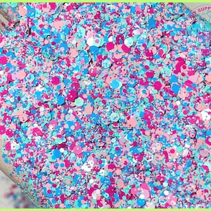 May include: A close-up of a mix of pink, blue, and green glitter. The glitter is in a variety of sizes and shapes.