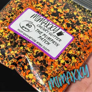 May include: A bag of chunky glitter in orange, yellow, and black. A label reads "MIMAXXY CHUNKY GLITTER THE PUMPKIN PATCH" with 60 grams of glitter. The Etsy shop address is also printed on the label.