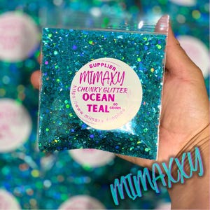 May include: A close-up of a teal chunky glitter in a clear plastic bag. The bag has a white label with the text "SUPPLIER MIMAXY CHUNKY GLITTER OCEAN TEAL 60 GRAMS https://www.mimaxysupplies.com".