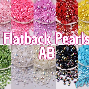 May include: Assortment of flatback pearls in various colors, including pink, white, green, blue, red, yellow, and iridescent black. The pearls are arranged in rows on a white background. The text "Flatback Pearls AB" is displayed in the center of the image.