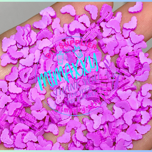 Puede incluir: Una gran cantidad de pequeñas chispas de plástico en forma de mariposa de color rosa.