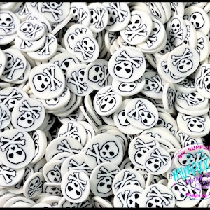 May include: A large quantity of white round resin cabochons with a black skull and crossbones design.