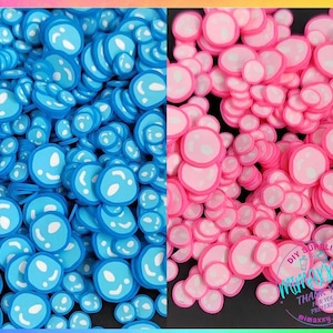 May include: A large quantity of blue and pink smiley face shaped resin embellishments. The embellishments are perfect for adding a fun and whimsical touch to crafts and projects.