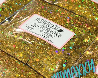 May include: Close-up of several bags of chunky holographic glitter in gold. Each bag has a label with the text "MIMAXXY," "CHUNKY GLITTER," "HOLOGRAPHIC," "EGYPTIAN GOLD," and "60 grams." The glitter has a mix of colors.