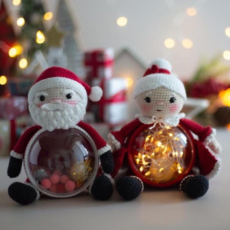 Peut inclure: Deux figurines de No&euml;l crochet&eacute;es : le P&egrave;re No&euml;l et la M&egrave;re No&euml;l. Le P&egrave;re No&euml;l porte un chapeau et un costume rouges avec une barbe blanche. La M&egrave;re No&euml;l a un bonnet blanc et une tenue rouge. Les deux ont des chaussures noires. Les ventres transparents contiennent des d&eacute;corations et des guirlandes lumineuses.