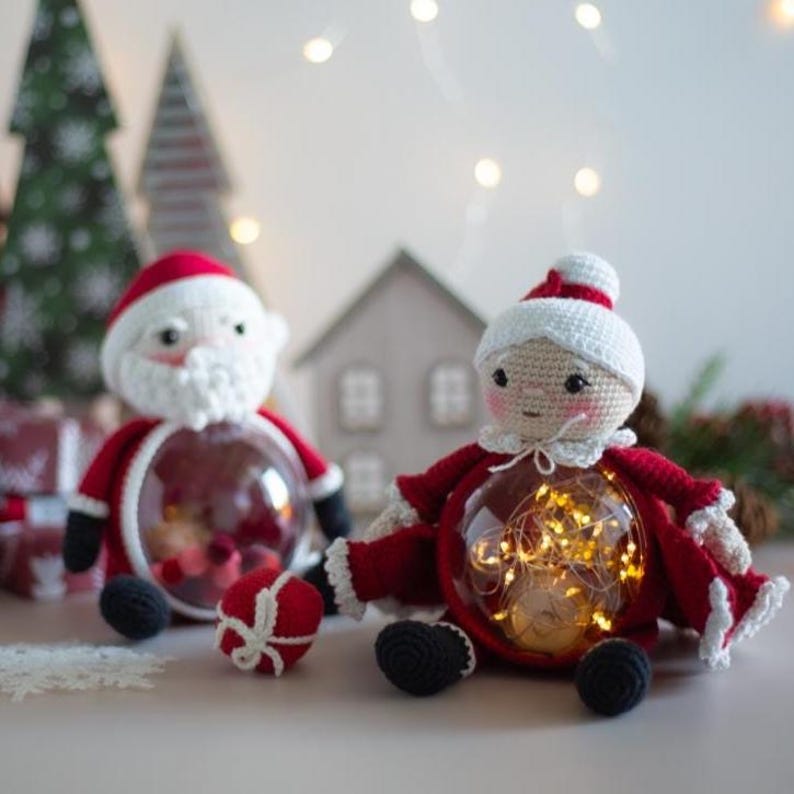 Peut inclure: Deux figurines du P&egrave;re No&euml;l au crochet, une masculine et une f&eacute;minine, avec des ventres transparents. Le P&egrave;re No&euml;l masculin a une barbe blanche et un costume rouge. Le P&egrave;re No&euml;l f&eacute;minin a un chapeau blanc et un costume rouge. Les deux ont des chaussures noires.