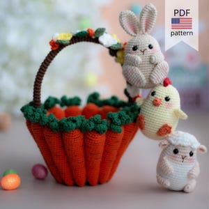 Peut inclure: Un panier de Pâques en crochet en forme de carottes avec un dessus vert feuillu. Le panier est rempli d'œufs de Pâques et décoré de fleurs. Un lapin, un poussin et un agneau en crochet sont assis sur le panier. Modèle PDF.