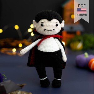 May include: Crochet amigurumi pattern for a cute vampire doll. The doll is wearing a black and white outfit with a red cape. The pattern is available as a PDF download.