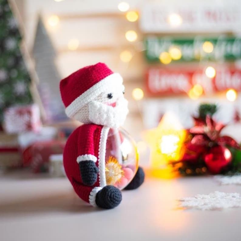 Peut inclure: Ornement fait main en crochet repr&eacute;sentant le P&egrave;re No&euml;l. Le personnage rouge et blanc du P&egrave;re No&euml;l a un corps en forme de globe en verre transparent rempli de fleurs s&eacute;ch&eacute;es. D&eacute;coration de No&euml;l festive.