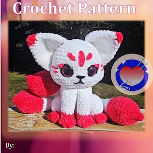 May include: A white and red crochet fox with large ears and a fluffy tail. The text "Kitsune Crochet Pattern" is at the top, and "Freedom Crochet by ME" is at the bottom.