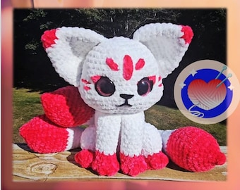 May include: A white and red crochet fox with large ears and a fluffy tail. The text "Kitsune Crochet Pattern" is at the top, and "Freedom Crochet by ME" is at the bottom.