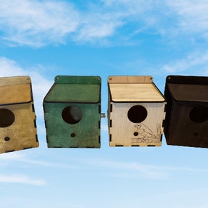 Può includere: Quattro casette per uccelli in legno di diversi colori: beige, verde, legno naturale e nero. Ogni casetta ha un'apertura rotonda per consentire agli uccelli di entrare.