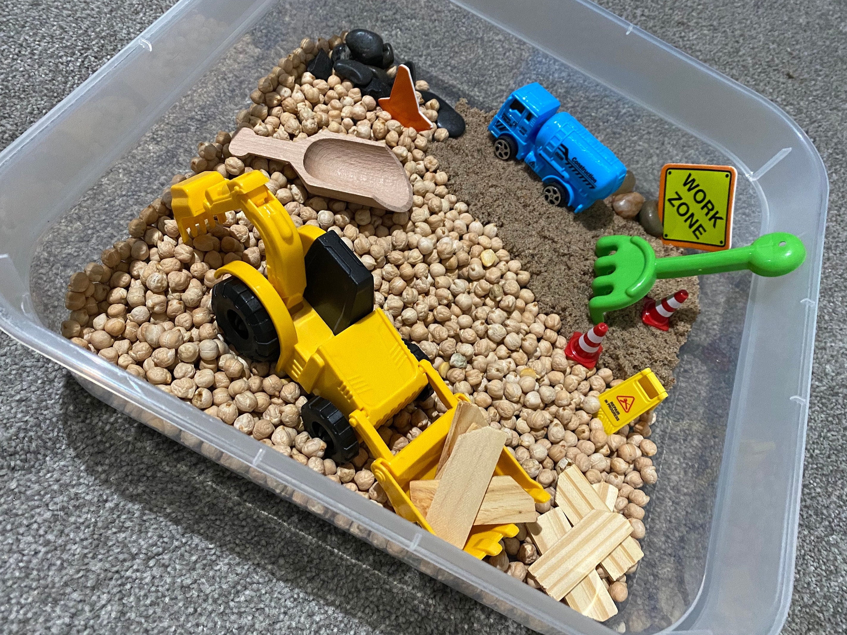 Construction site sensory bin with kinetic sand fill. Build, truck, pile,  stack, move and drive all around the…