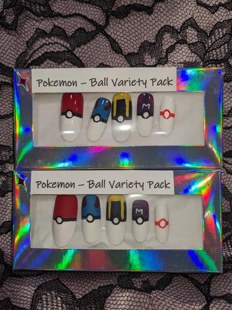 May include: Two boxes of Pokemon Ball Variety Pack press-on nails. Each box contains six nails with different Pokemon ball designs. The designs include a red and white Pokeball, a blue and white Pokeball, a yellow and black Pokeball, a purple and black Pokeball, and a red and white Pokeball with a red ring.