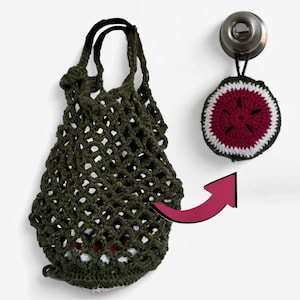 May include: A dark green crocheted market bag with a black handle hangs next to a crocheted watermelon slice. The watermelon slice has a red center, white rind, and green edge. The bag is open weave.