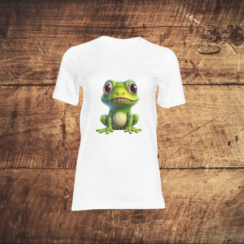 May include: White t-shirt with a green frog graphic. The frog has large eyes and a wide smile.