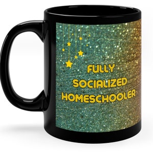 May include: Black coffee mug with a glittery green and gold background. The text "FULLY SOCIALIZED HOMESCHOOLER" is printed in yellow on the mug.