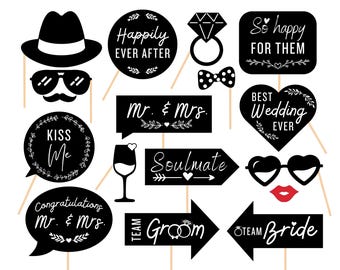 May include: A set of 12 black and white wedding photo booth props with various sayings and designs. The props include a bow tie, sunglasses, a ring, a heart, and a speech bubble that says "Kiss Me".