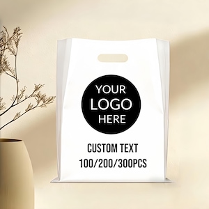以下が含まれることがあります： ダイカットハンドル付きの白いプラスチックショッピングバッグ。黒い円には「YOUR LOGO HERE」という文字が表示されています。その下に「CUSTOM TEXT」という文字が印刷され、その後に「100/200/300PCS」と続きます。