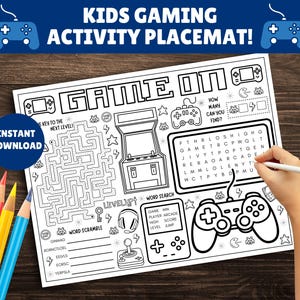 May include: A black and white kids gaming activity placemat with the text "KIDS GAMING ACTIVITY PLACEMAT!" and "GAME ON". The placemat includes a maze, word search, and word scramble. A hand is holding a pen.