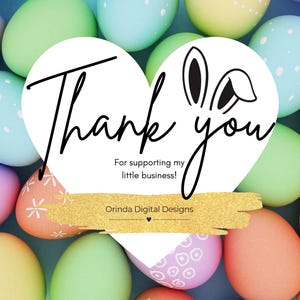 May include: A white heart-shaped thank you card with bunny ears on top. The card has gold glitter accents and the text "Thank you" in black cursive. The card is surrounded by colorful Easter eggs.