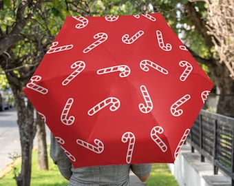 Paraguas rojo con forma de bastón de caramelo para protegerse de la lluvia o del sol. Ideal para el invierno, como regalo para fiestas de Navidad, un accesorio acogedor para las fiestas que te mantiene seco