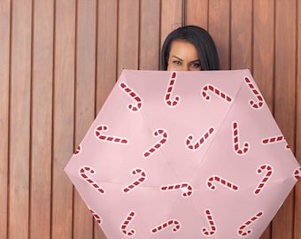 Paraguas de bastón de caramelo rosa para protección contra la lluvia o el sol. Ideal para el invierno, como regalo de fiesta de Navidad, moda navideña acogedora que te mantiene seco.