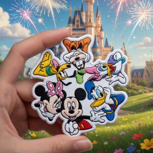 May include: Embroidered patch featuring Mickey Mouse, Minnie Mouse, Donald Duck, Goofy, and other Disney characters. The patch is white with colourful details and a white border. The background shows a castle and fireworks.