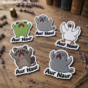 May include: Five embroidered patches featuring a green frog, a gray seal, a white goose, and a brown raccoon, all crying and displaying middle fingers. Each patch includes the text Aur Naur in black lettering on a white background border.