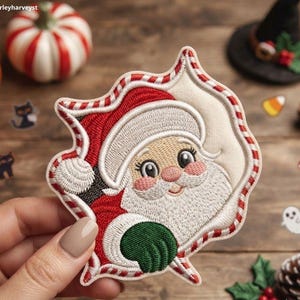 May include: An embroidered patch featuring a cartoon Santa Claus with a white beard, red hat, and green mitten, framed by a red and white candy cane striped border. The patch has a cream-colored background and displays the text Beverleyharveyst.
