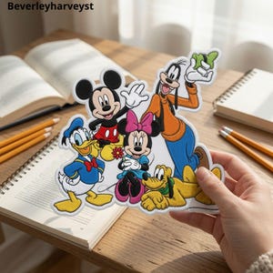 May include: A fabric patch featuring embroidered Disney characters including Mickey Mouse, Minnie Mouse, Donald Duck, Goofy, and Pluto. The colorful design shows the group together in a cheerful pose. The text Beverleyharveyst is visible in the corner.