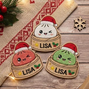 May include: Three embroidered patches featuring cute, winking dumpling characters in bamboo steamers. Each dumpling wears a red and white Santa hat. The steamers are labeled with the name LISA in black text, accented by a yellow star and holly.