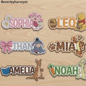 Puede incluir: Seis placas de nombre personalizadas con personajes de Winnie the Pooh. Los nombres Sophia, Leo, Than, Mia, Amelia y Noah se muestran con iconos temáticos que incluyen a Piglet, Pooh, Igor, Tigger, Rito y Conejo, junto a margaritas y zanahorias.