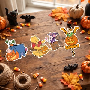 Może przedstawiać: Cztery wycinane naklejki przedstawiające postacie z Kubusia Puchatka w kostiumach na Halloween: Kłapouchy z dynią, Puchatek z wiaderkiem w kształcie dyni, Prosiaczek w czapce czarownika w torbie z napisem Trick or Treat oraz Tygrysek w dyni.