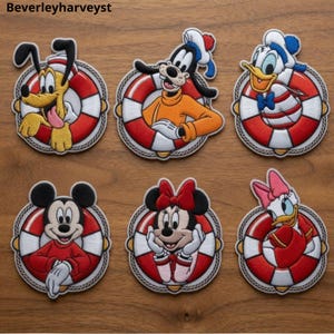 May include: Six embroidered patches featuring cartoon characters Pluto, Goofy, Donald Duck, Mickey Mouse, Minnie Mouse, and Daisy Duck, each positioned inside a red and white life preserver ring with rope detailing around the outer edge.
