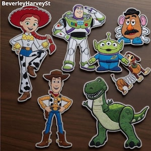 May include: A collection of embroidered patches featuring characters from the animated film Toy Story. The patches include Woody, Buzz Lightyear, Jessie, Mr. Potato Head, Rex, and the Little Green Men, with detailed stitching and vibrant colors.