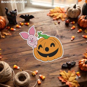 Puede incluir: Una pegatina troquelada que muestra a un personaje de cerdo rosa claro asomándose detrás de una calabaza naranja sonriente con un tallo verde. El diseño tiene un borde blanco y se muestra sobre un fondo de madera rústica con decoración otoñal.