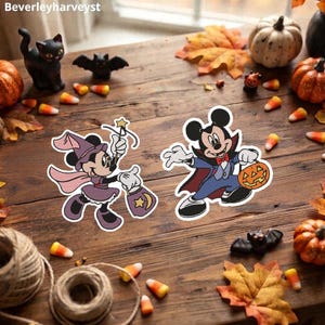 Pode incluir: Dois emblemas bordados com personagens da Disney. Um emblema mostra uma personagem com um traje de bruxa roxo segurando uma varinha e um saco de doces. O outro mostra uma personagem com um traje de vampiro segurando um balde de abóbora.