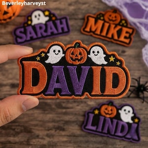 May include: A rectangular embroidered patch featuring the name DAVID in large purple and orange letters. The design includes two white ghosts and a central orange jack-o'-lantern on a black background, accented with small yellow stars.