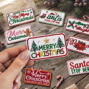 Könnte beinhalten: Eine Sammlung rechteckiger bestickter Aufnäher mit Weihnachtsmotiven, darunter Schriftzüge wie Merry Christmas, Santa Stop Here und Believe, mit Designs von Tannenbäumen, Stechpalmen, Weihnachtssternen und Lebkuchenmännern in Rot, Grün und Weiß.