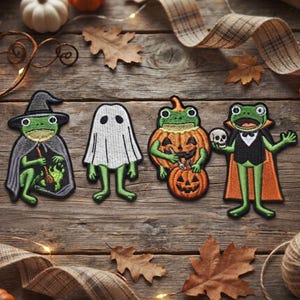 Könnte beinhalten: Vier gestickte Aufnäher mit grünen Fröschen in Halloween-Kostümen: eine Hexe mit Kessel, ein Geist, ein Frosch in einem Kürbis und ein Vampir mit einem Totenkopf. Der Text Beverleyharveyst ist oben links im Bild zu sehen.