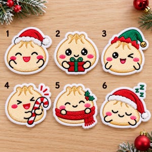 Puede incluir: Seis parches bordados con dibujos de dumplings con caras. El número 1 lleva un gorro de Papá Noel. El 2 sostiene un regalo rojo. El 3 lleva un gorro de elfo. El 4 sostiene un bastón de caramelo. El 5 lleva una bufanda roja con acebo.