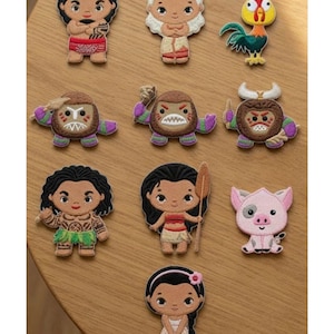 May include: A collection of ten embroidered patches featuring cartoon characters, including figures with dark hair, a rooster, a pig, and three round creatures with horns and teeth. The text Beverleyharveyst is visible in the top left corner.
