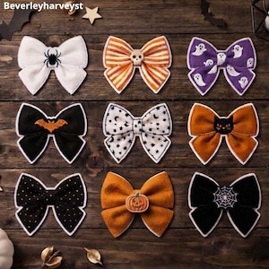 May include: Nine fabric hair bows arranged in a grid, featuring Halloween-themed patterns including a black spider, orange stripes with a skull, white ghosts on purple, a bat, stars and moons, a black cat, polka dots, a pumpkin, and a spiderweb.