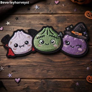 Puede incluir: Tres parches bordados con personajes adorables: una empanadilla vampiro de color violeta claro con alas negras, una empanadilla verde inspirada en Frankenstein con costuras y una empanadilla morada con un sombrero de bruja negro y banda naranja.