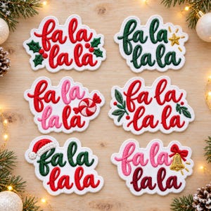 May include: Six embroidered patches with white backgrounds, each featuring the text fa la la la in various colors and fonts. Designs include holly leaves, a gold star, a peppermint candy, greenery, a Santa hat, and a gold bell.