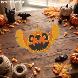 Puede incluir: Un parche bordado que presenta una calabaza naranja estilizada con orejas grandes y puntiagudas y una cara de jack-o'-lantern negra. El diseño incluye una sonrisa ancha y dentada y ojos circulares, imitando la forma de un personaje.